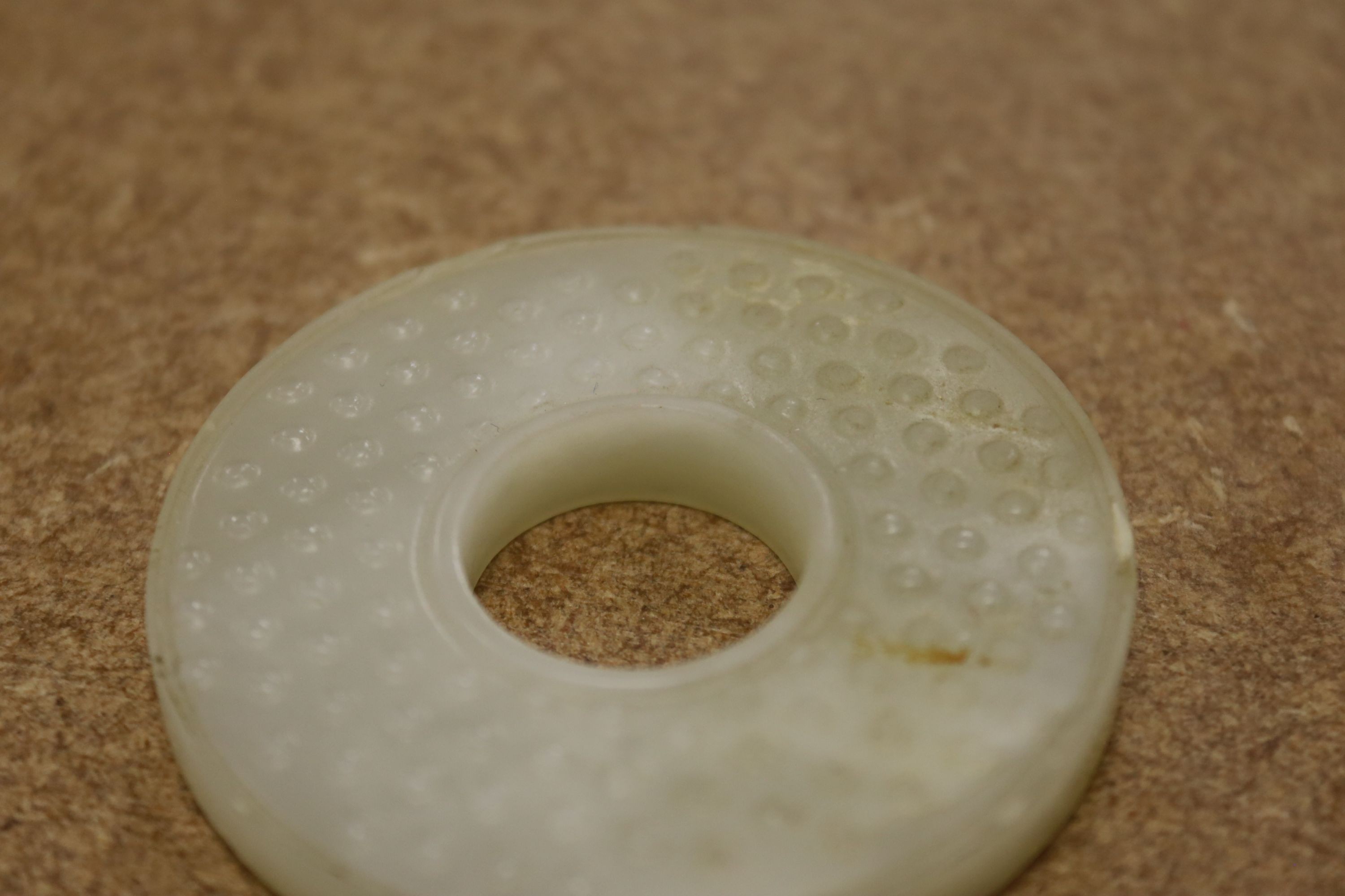 A Chinese pale celadon jade bi disc, 6cm diameter
